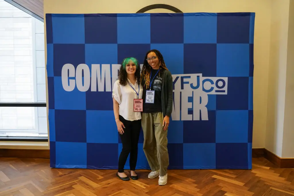 Two campaign members in front of a conference backdrop. Photo by Armando Geneyro.